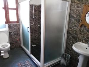 a bathroom with a shower and a toilet and a sink at Airport Link Guest House in Entebbe