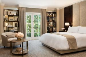 a bedroom with a bed and a chair and a window at Rosewood Mansion on Turtle Creek in Dallas