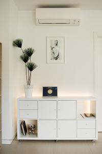 a white dresser in a white room with a plant at Villa Magnolia in Torri del Benaco