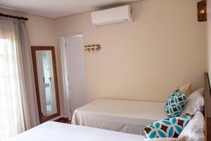 1 Schlafzimmer mit 2 Betten und Klimaanlage in der Unterkunft Pousada Camburi in Camburi