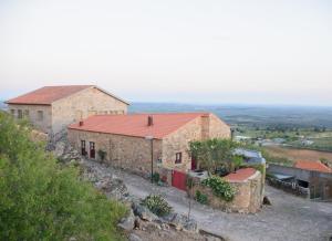 Quelques bâtiments en briques sur une colline dans l'établissement Casa da Amendoeira, à Castelo Rodrigo