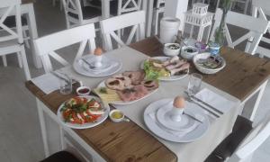 drewniany stół z talerzami żywności w obiekcie Pokoje na plaży w mieście Ustronie Morskie
