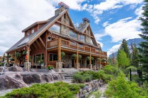a log home with a mountain at The Hidden Ridge Resort in Banff