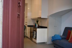 Una sala de estar con un sofá y una cocina. en Casa Barão Forrester, en Oporto 12 fotos más