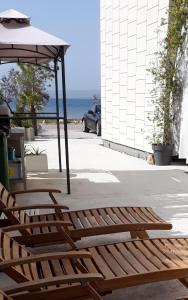 a patio with a bench and an umbrella and the ocean at St.Barth Apartments in Šibenik