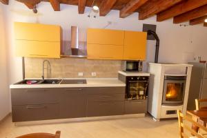 a kitchen with yellow cabinets and an oven with a stove at La Colomba B&B in Castellaro