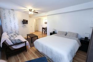 a bedroom with a white bed and a living room at Cedar Drive Inn in Crysler