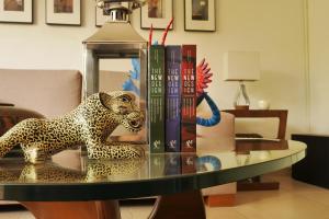 een glazen tafel met een luipaard standbeeld en boeken erop bij Habitación Privada para disfrutar en la Ciudad de México in Mexico-Stad