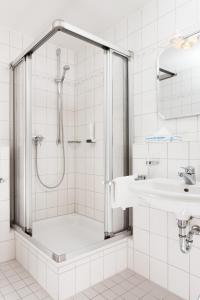 y baño con ducha y lavamanos. en Brauereigasthof/Hotel Bürgerbräu, en Bad Reichenhall