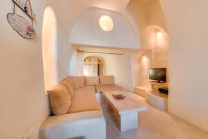a living room with a couch and a table at Christina's Cave House in Fira
