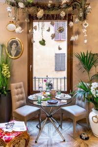 une table et des chaises dans une pièce ornée de plantes dans l'établissement 051 Room & Breakfast, à Bologne