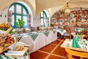 a restaurant with tables and a mural on the wall at Brauereigasthof/Hotel Bürgerbräu in Bad Reichenhall
