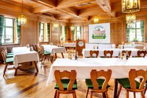 een eetkamer met witte tafels en stoelen bij Brauereigasthof/Hotel Bürgerbräu in Bad Reichenhall