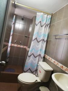 uma casa de banho com um WC, um chuveiro e um lavatório. em Hostal Mariscal Sucre em Tababela