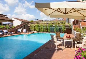 a swimming pool with chairs and an umbrella at Hotel Francia E Quirinale in Montecatini Terme
