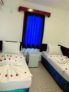 Habitación con 2 camas y cortina azul en Bodrum Blu Hotel, en Bodrum City