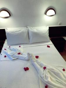 a white bed with red flowers on it at Bodrum Blu Hotel in Bodrum City