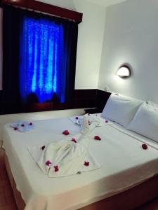 a bed with red flowers on it with a blue window at Bodrum Blu Hotel in Bodrum City