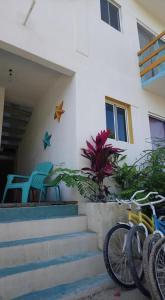 a house with two chairs and a bike parked outside at Casa Vainilla Holbox Island in Holbox Island