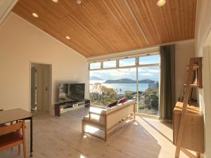 a living room with a large window and a television at La Krasse Angelroad in Tonosho