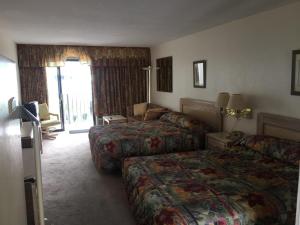 um quarto de hotel com duas camas e uma varanda em David's Landing em Myrtle Beach