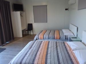 a hotel room with two beds and a window at Pine Lake View Lodge in Kaiapoi