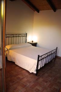 1 dormitorio con 1 cama grande con colcha blanca en Agriturismo San Mauro, en Capalbio