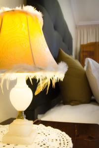a yellow lamp on a table next to a bed at De Zoete Rust Guesthouse in Centurion