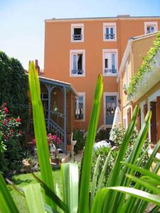 a view of a building from a garden with plants at Hôtel de la Tour in Les Sables-d'Olonne