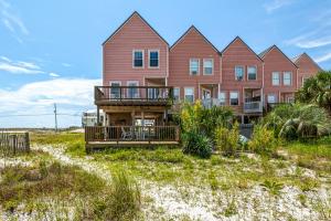 a large red house with a balcony on the beach at Sea La Vie Townhouse in Navarre