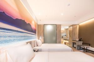 a hotel room with two beds and a painting on the wall at Atour Hotel Qingdao Airport Chengyang Wanxianghui in Qingdao