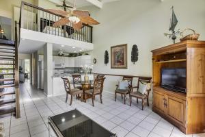a kitchen and dining room with a table and a television at Pupukea Condo in Kahuku
