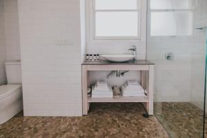 ein Badezimmer mit einem Waschbecken und einer Theke mit Handtüchern in der Unterkunft Seabreeze Hotel in Nelson Bay