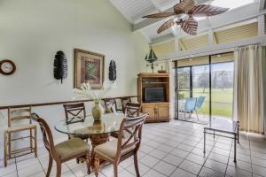 a dining room with a table and chairs and a television at Pupukea Condo in Kahuku