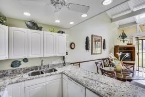a kitchen with white cabinets and a dining room at Pupukea Condo in Kahuku