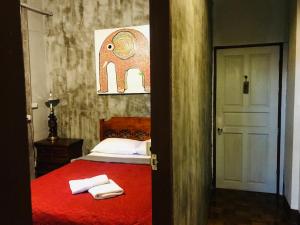 a bedroom with a red bed with towels on it at Bee Friend Hostel in Chiang Mai