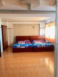 Giang Phuoc Hung hotel في مدينة هوشي منه: سريرين في غرفة ذات أرضيات خشبية