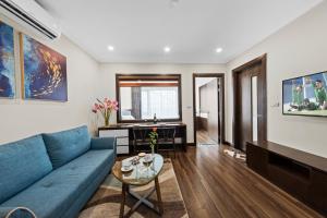 un soggiorno con divano blu e tavolo di Newsky Serviced Apartment a Hanoi