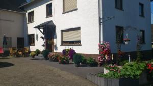 a building with a bunch of flowers in front of it at Pension Loni Theisen in Kelberg