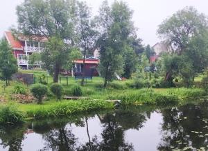 a view of a house from the river at River Side Studio, 9mi from Palanga, With sauna in Kretinga +8 photos