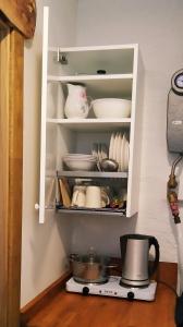 a cupboard with plates and dishes in it at River Side Studio, 9mi from Palanga, With sauna in Kretinga