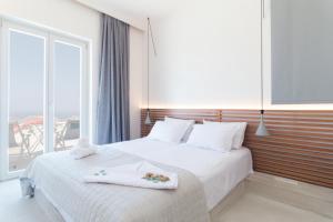 A bed or beds in a room at Wabi Luxury Suites & Maisonettes Ios
