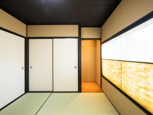 una habitación vacía con dos puertas y una ventana en Rinn Manjuji en Kioto