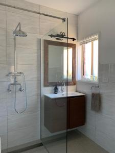a bathroom with a shower and a sink and a mirror at Bryn Glas Farm Stay in Moruya