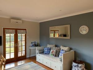a living room with a couch and a mirror at Bryn Glas Farm Stay in Moruya