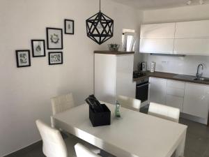 a kitchen with a white table and white chairs at Villa Lorenta Apartments in Primošten