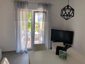 Televízia a/alebo spoločenská miestnosť v ubytovaní Villa Lorenta Apartments