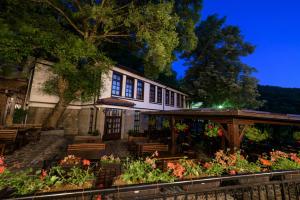 a building with benches and flowers in front of it at Hotel Manastir Sv. Joakim Osogovski in Kriva Palanka