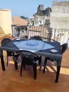einen schwarzen Tisch und Stühle auf dem Balkon in der Unterkunft Charme in Aci Castello in Aci Castello