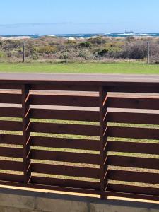 a wooden fence with the ocean in the background at Belair Gardens Caravan Park in Geraldton